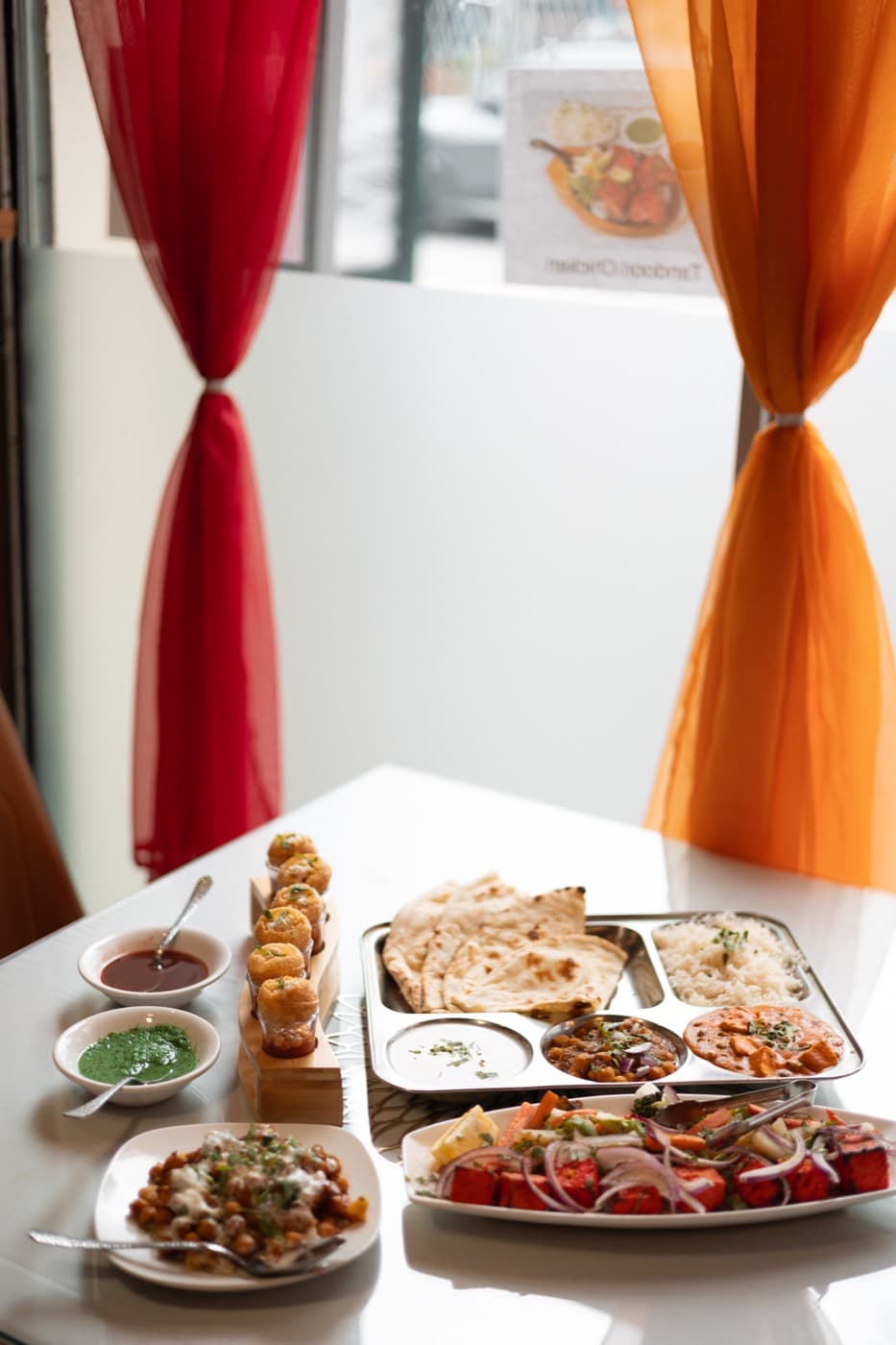 Full Jewel of India thali spread with tandoori chicken, butter paneer, chana masala, naan, basmati rice, and chutneys