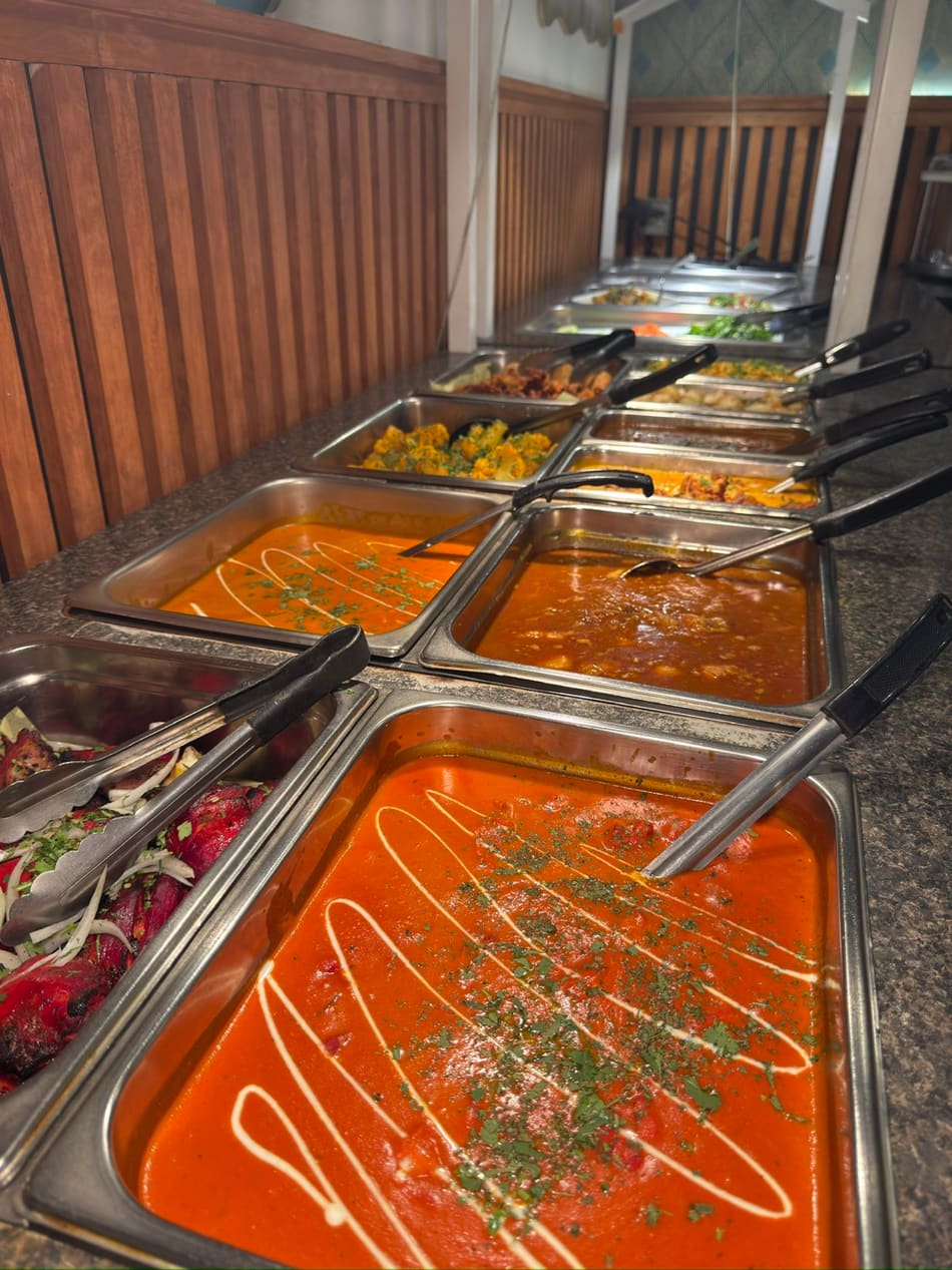 Jewel of India lunch buffet spread with butter chicken, tandoori chicken, and curries in stainless steel trays